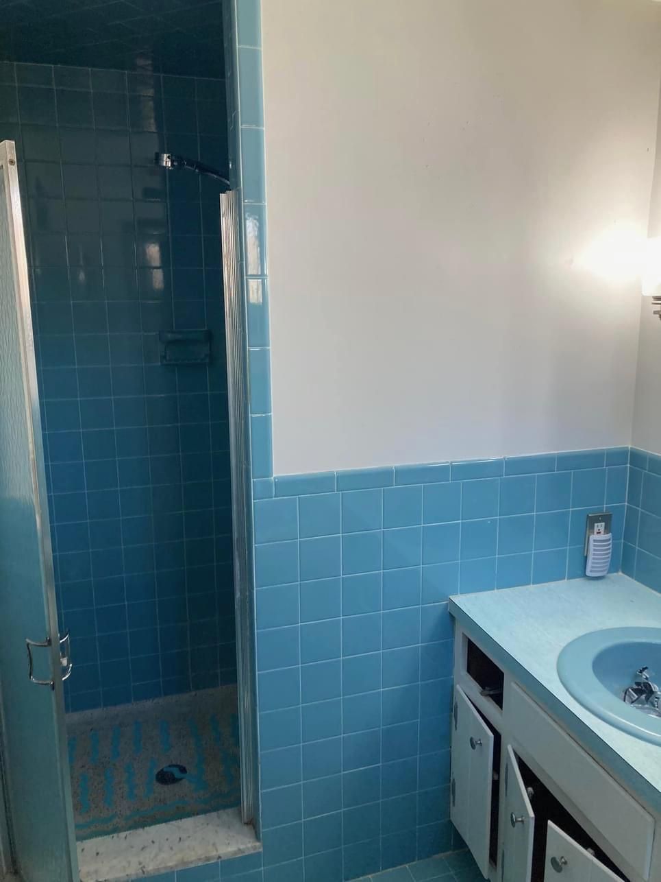 A bathroom with blue tiles and a walk in shower