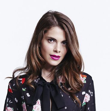 A brunette with bright pink lipstick