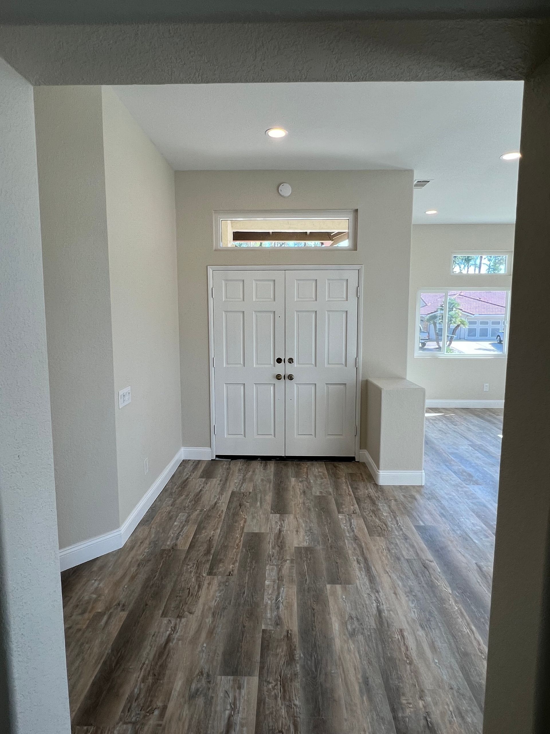 A hallway with hardwood floors and white doors in a house.