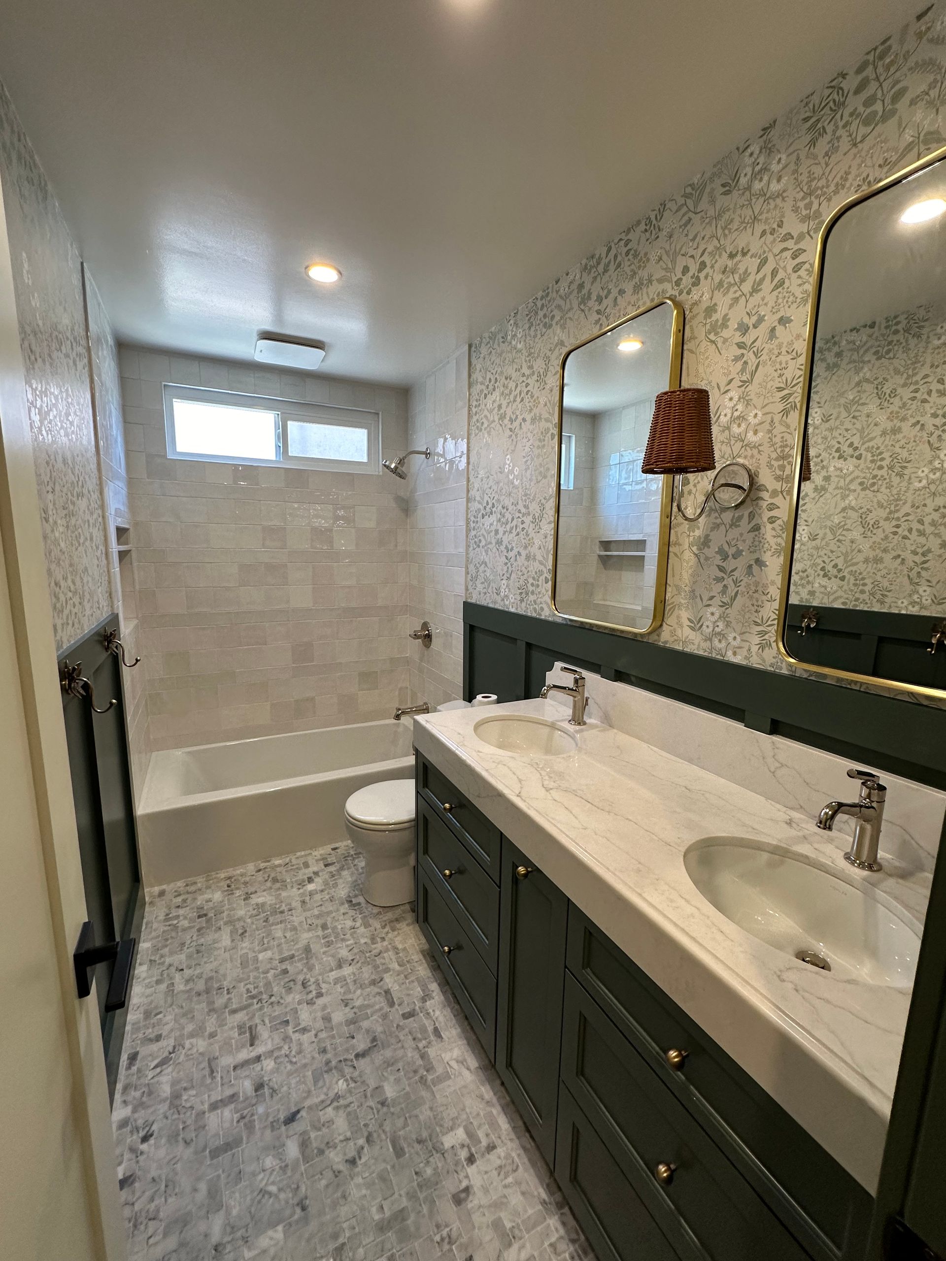 A bathroom with two sinks , a toilet , and a bathtub.