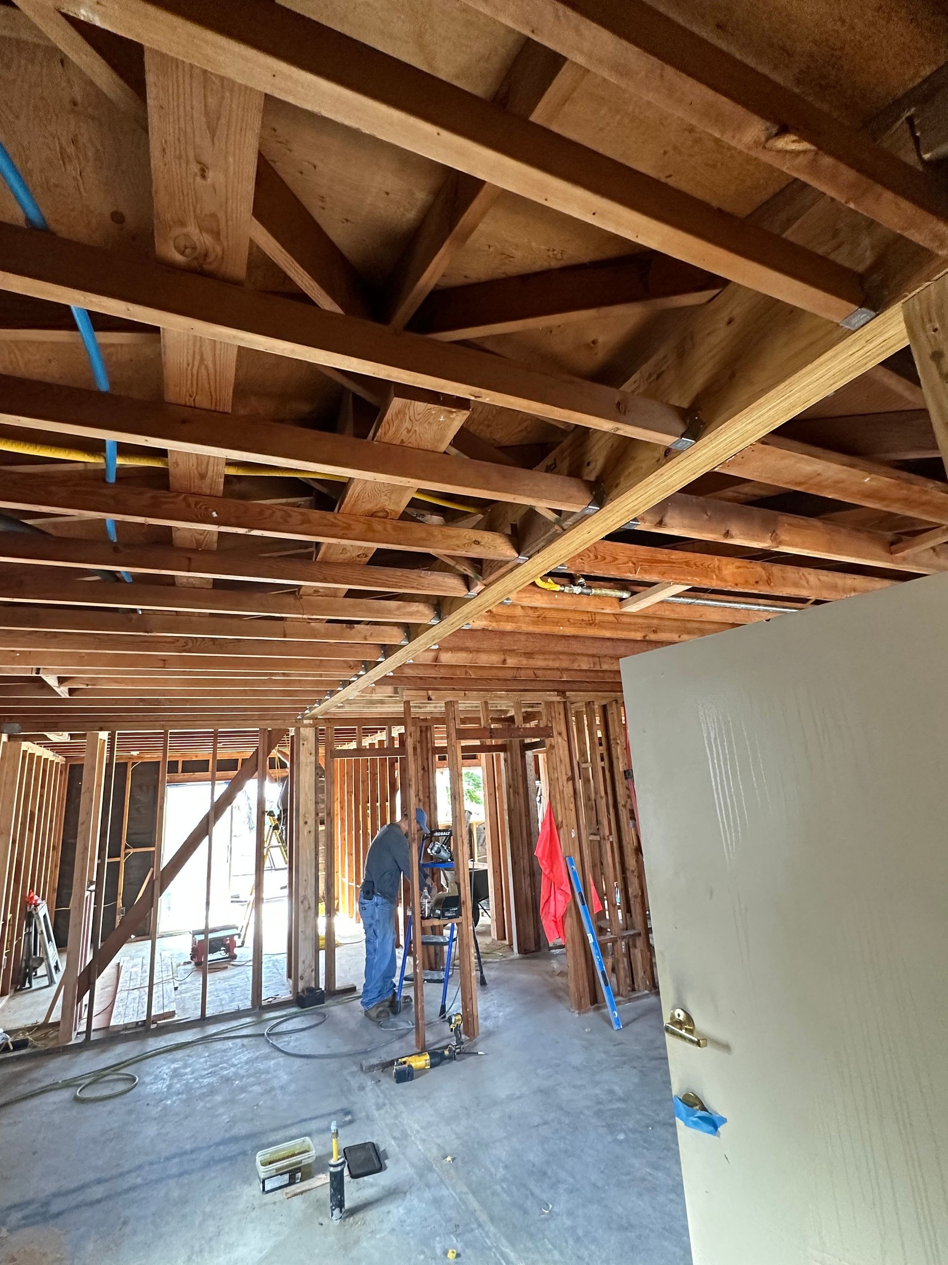 A man is standing in the middle of a room under construction.
