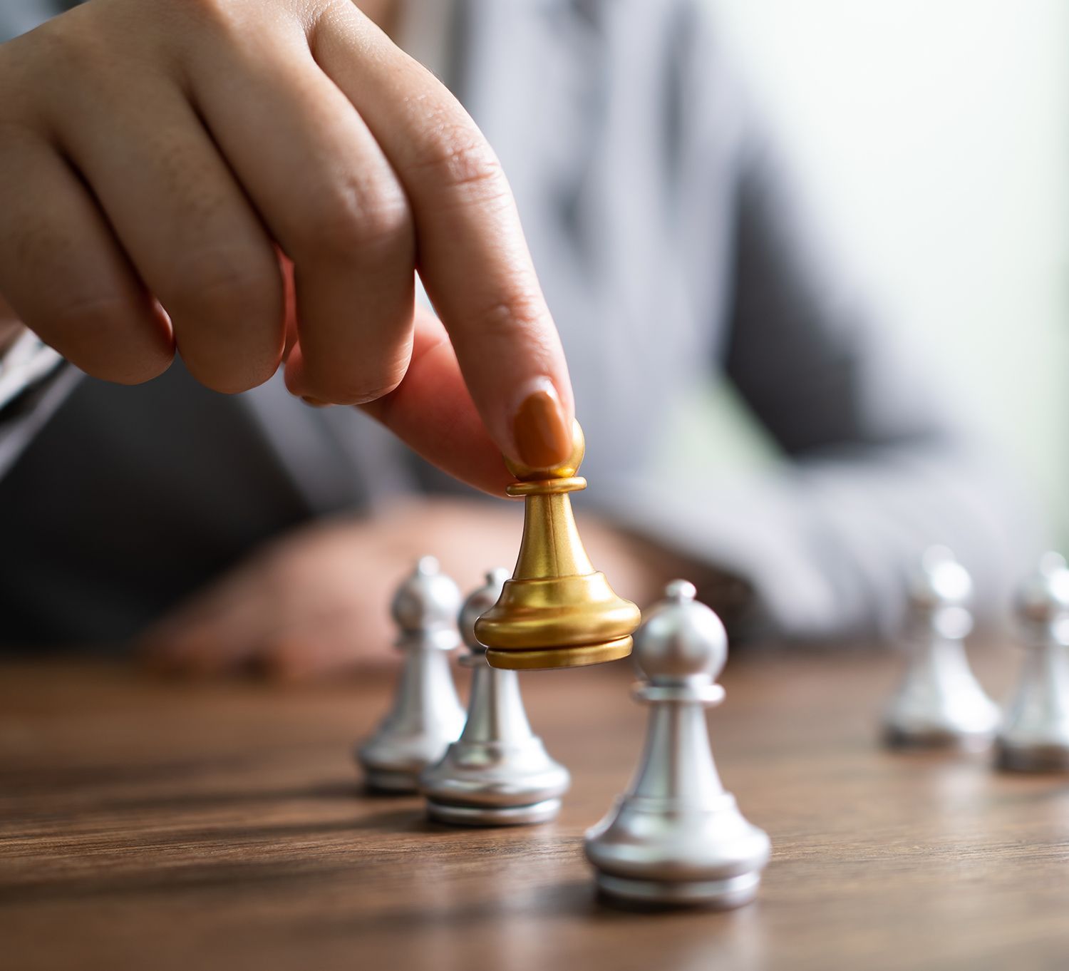 Hand moving a chess piece on chess board