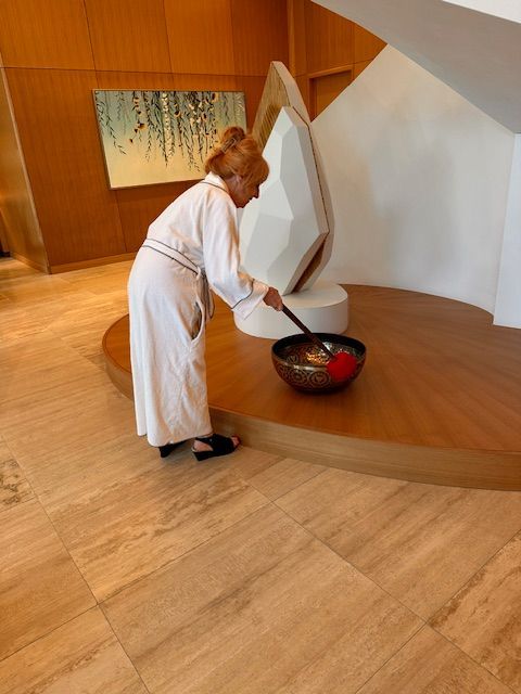 Lori Martorell on beach, looking at sunset over ocean. Warm colors, light reflecting on her face.