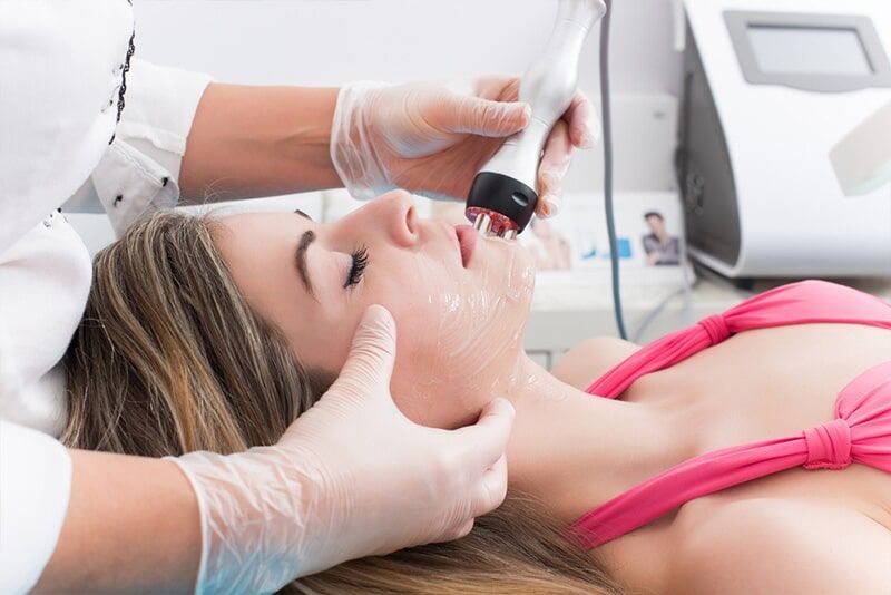 A Woman is Getting a Facial Treatment in a Beauty Salon — Bernadette's Beauty Care in Sarina, QLD