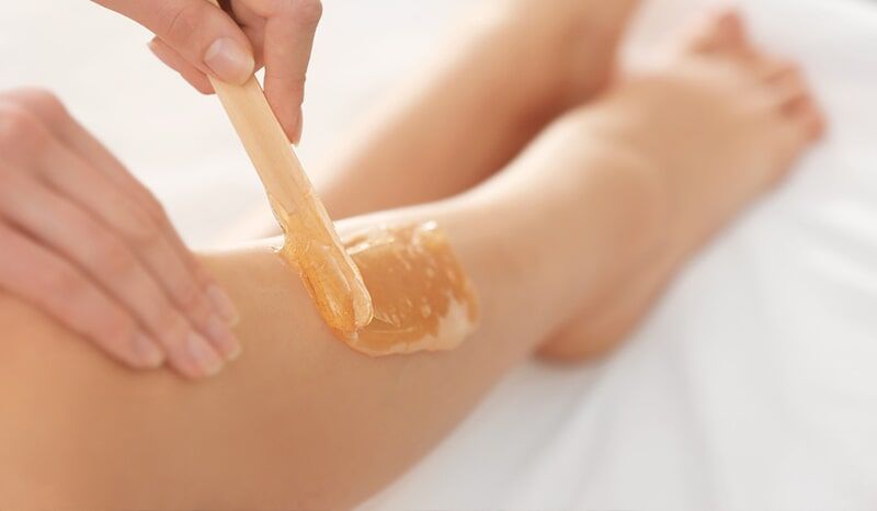 A Woman is Getting a Waxing Treatment on her leg — Bernadette's Beauty Care in Sarina, QLD