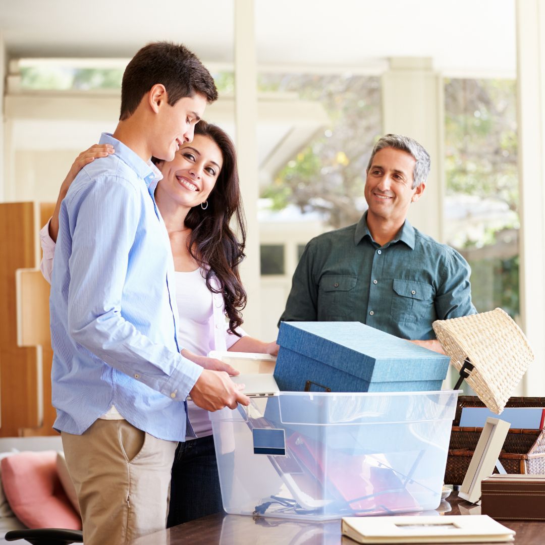 Family packing boxes in a home. Smiling, they embrace as they prepare for a move.