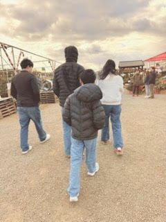 Family walking on a forest path, holding hands; green foliage surrounds them.