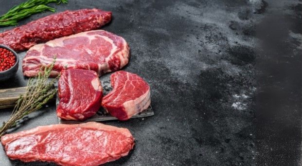 There are many different types of steaks on the table.