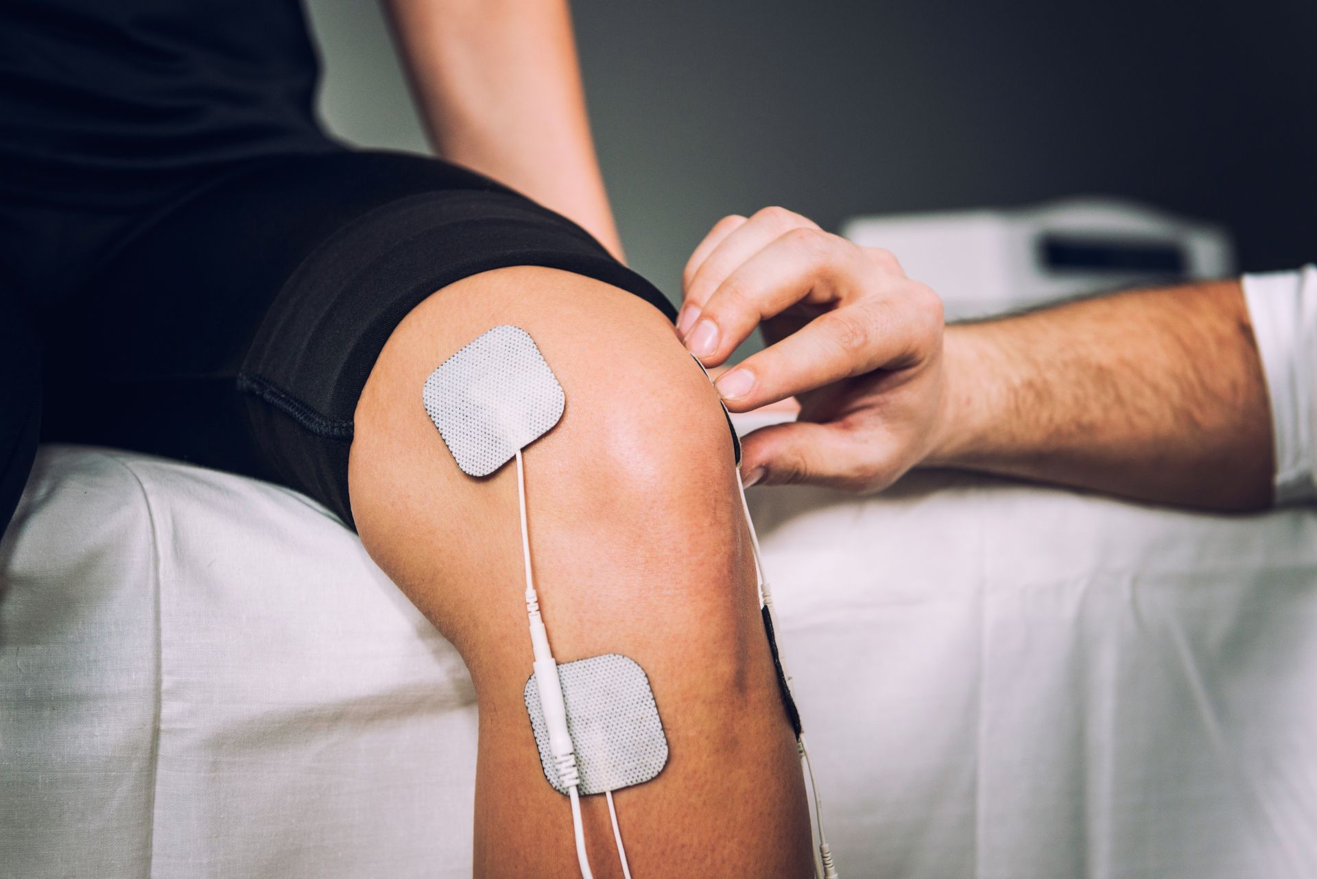 A person is getting electrodes on their knee.