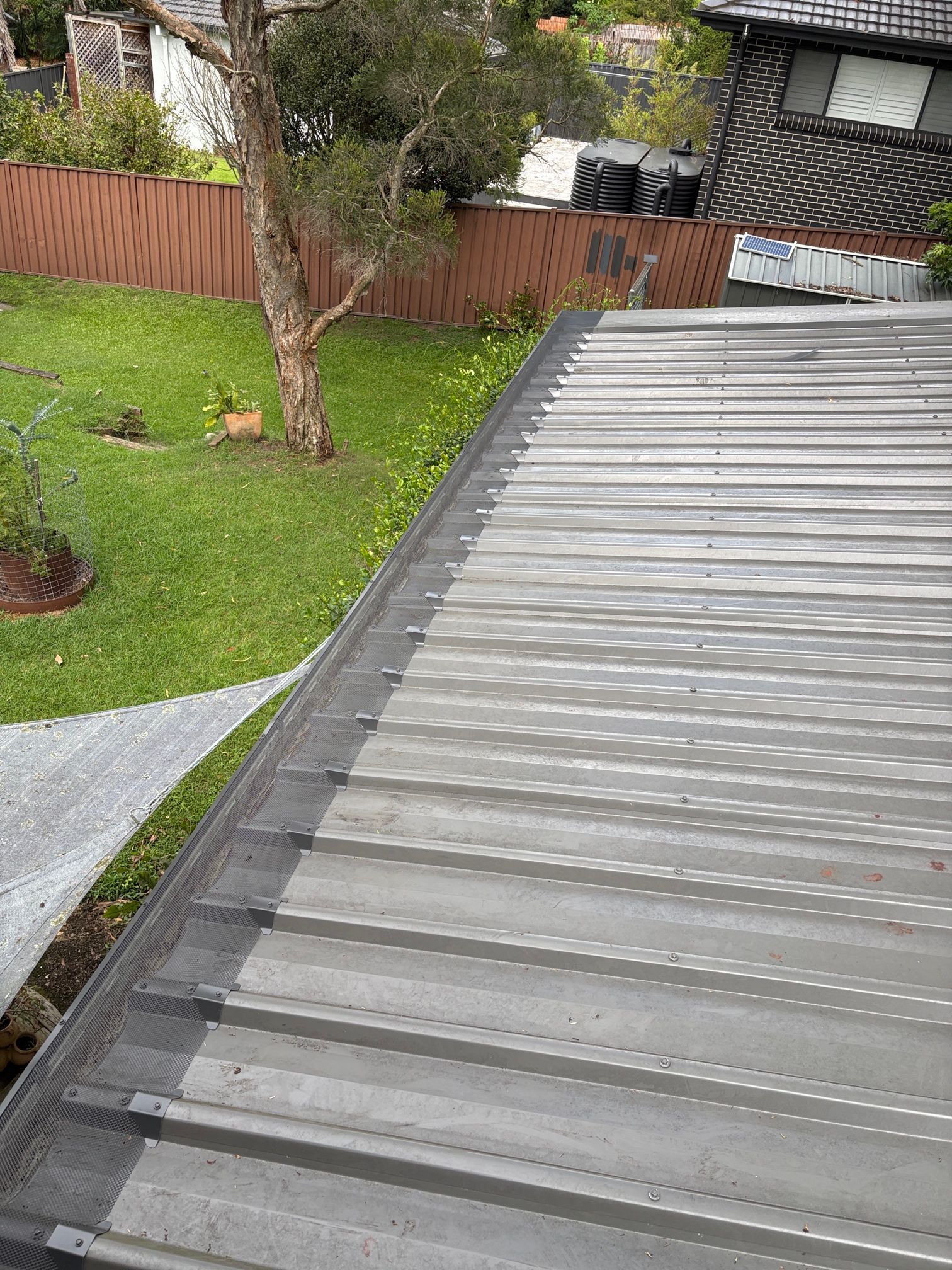 A gutter on the side of a roof with Gutter Guard