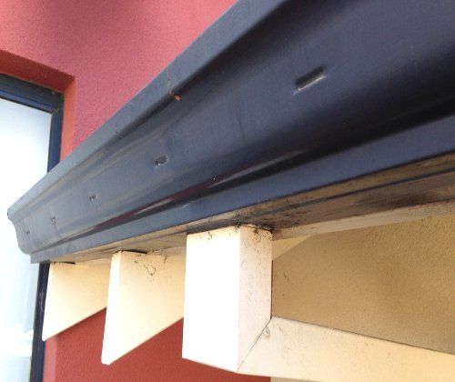 A red building with a black gutter on it