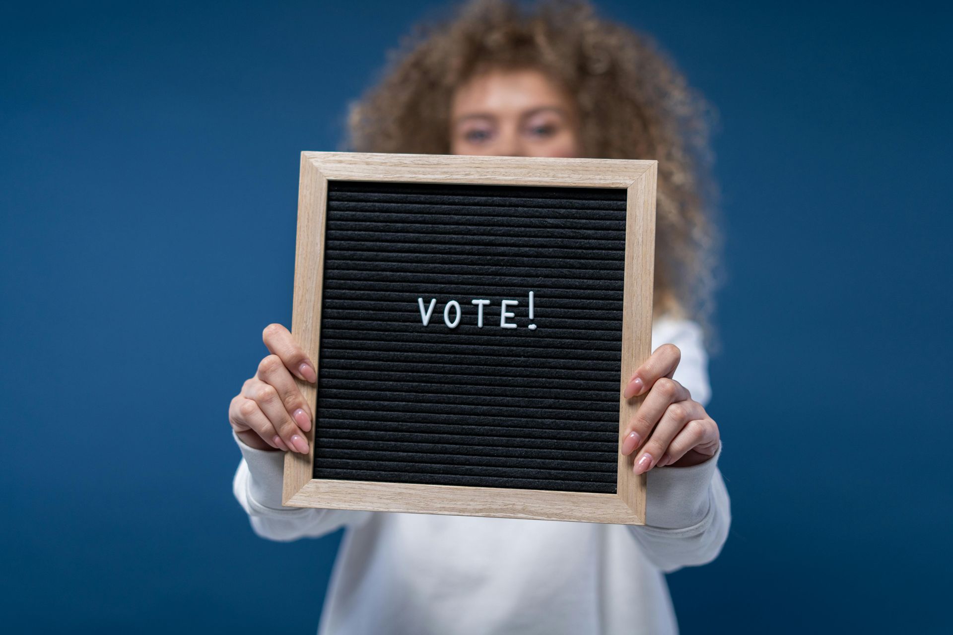 A woman is holding a sign that says vote.