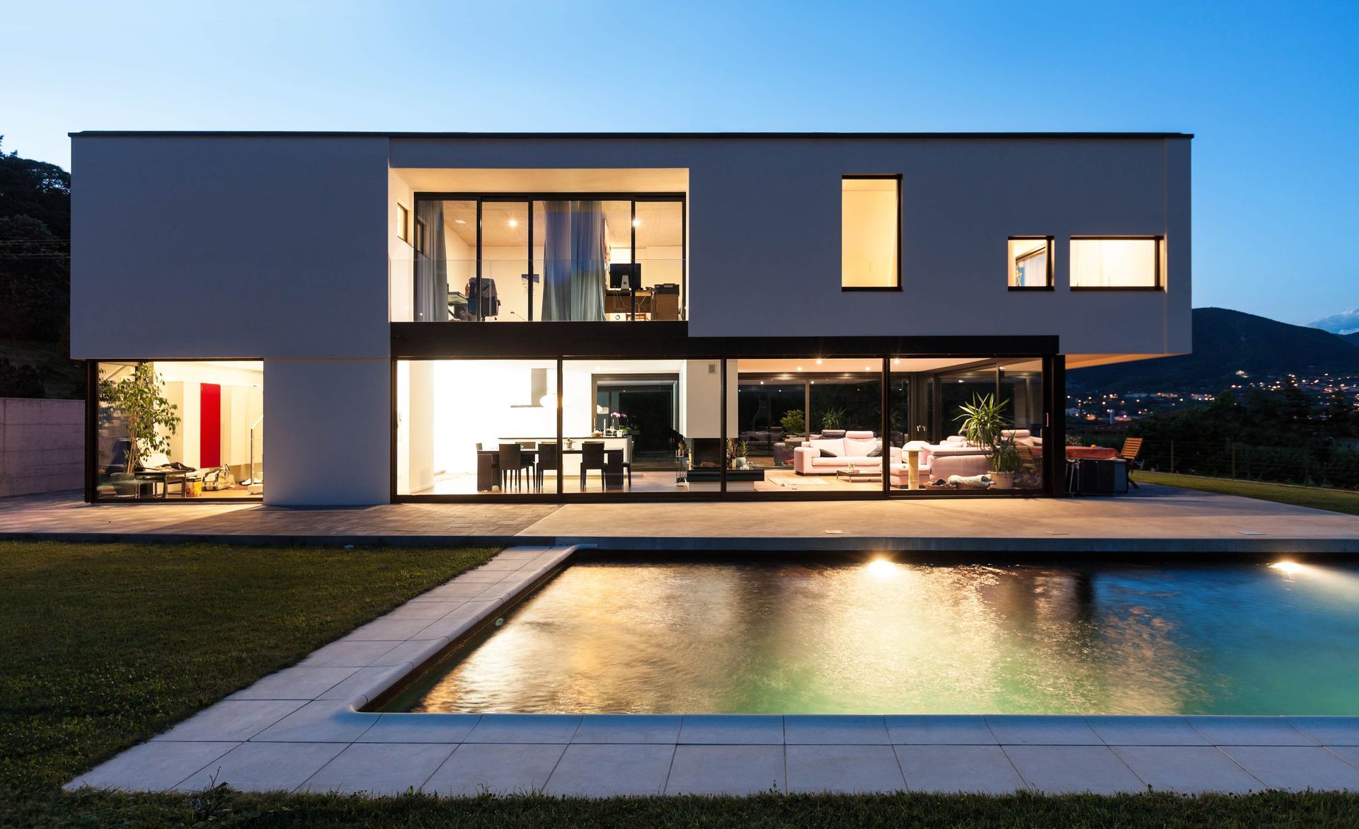 A modern house with a swimming pool in front of it.