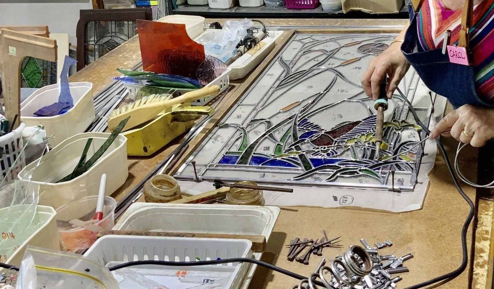 A Group Of People Are Working On A Stained Glass Window — Townsville Stained Glass In Aitkenvale, QLD
