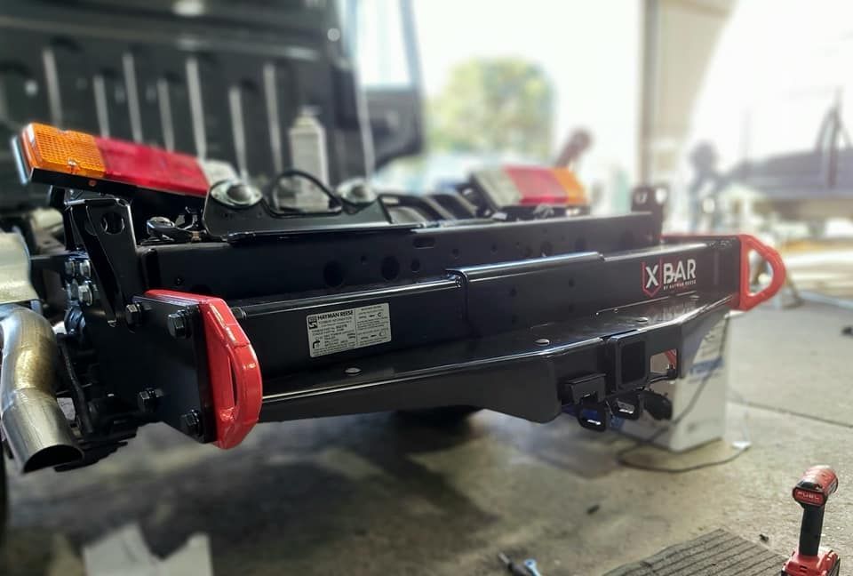 A Jeep With a Trailer Attached to It is Parked in a Garage — B & C Caravan Service Pty Ltd In Dubbo, NSW