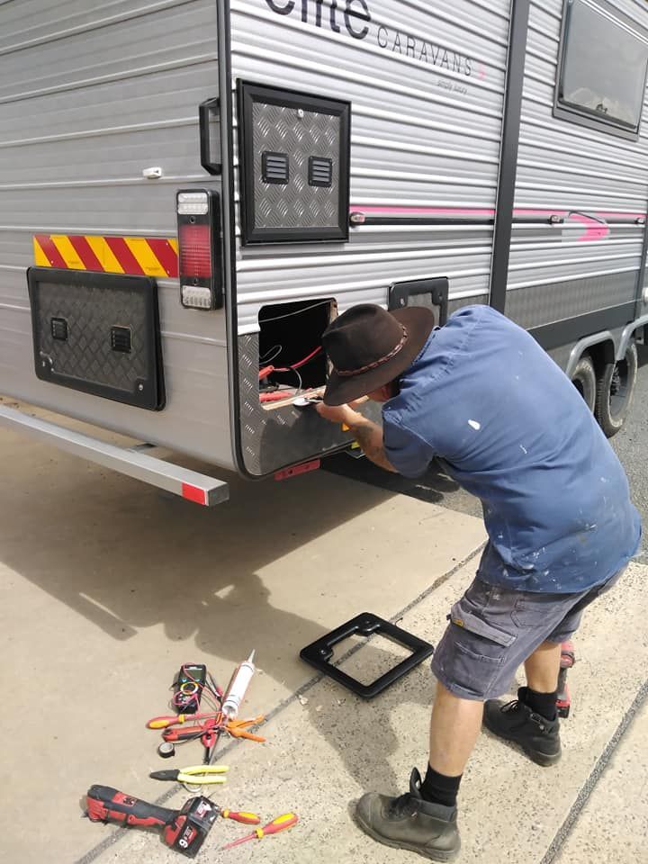A Man is Working on the Back of a Trailer — B & C Caravan Service Pty Ltd In Dubbo, NSW