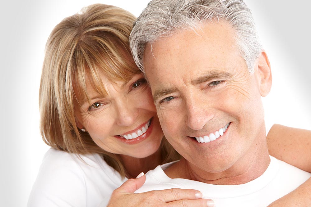 older couple with perfect white teeth who have crowns