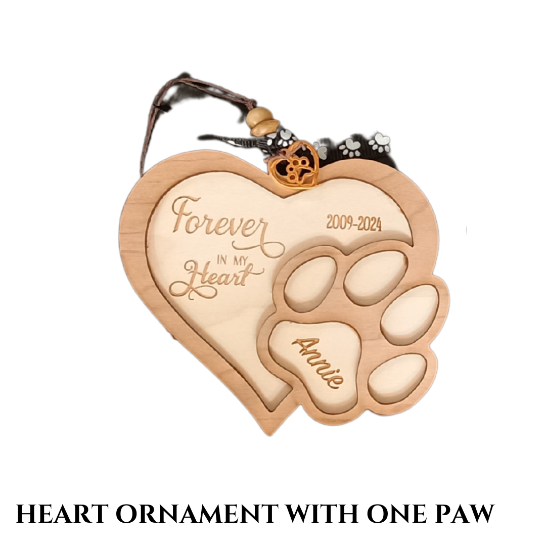Small, wooden heart-shaped ornament with one paw prints, dog's name, birth and death years, and a phrase.