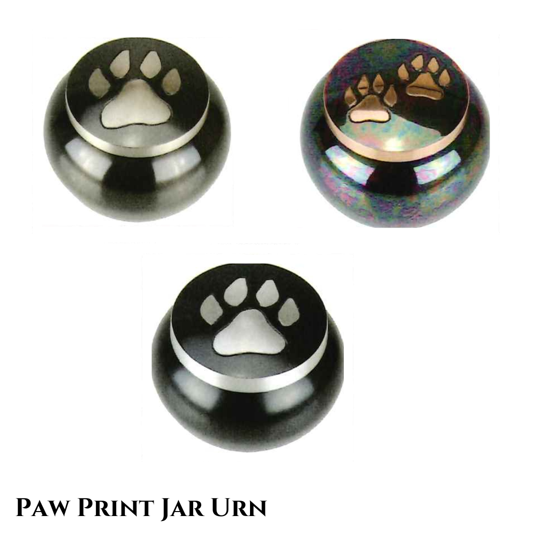 Small paw print jar urns in brass, raku and aluminum, all with paw prints on the lid.