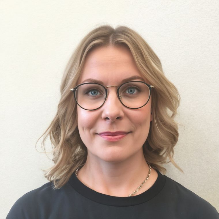 A woman wearing glasses and a black shirt smiles for the camera