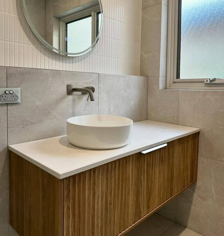 A Bathroom With A Sink And A Mirror On The Wall — Penman Projects In Salamander Bay, NSW