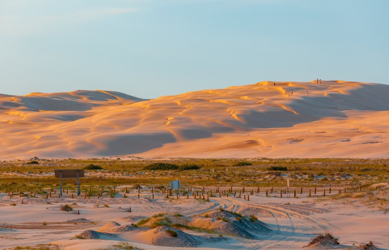 A Desert Landscape With Mountains In The Background And Sand Dunes In The Foreground — Penman Projects In Anna Bay, NSW