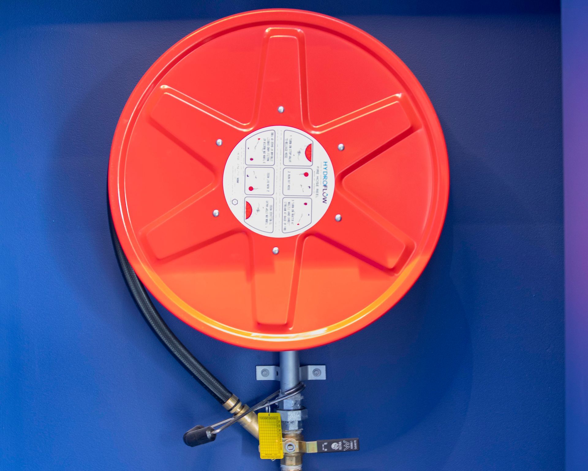 A Blue And Orange Water Pipe Is Sitting On Top Of A Lush Green Field — Frank Plumbing In Delacombe, VIC