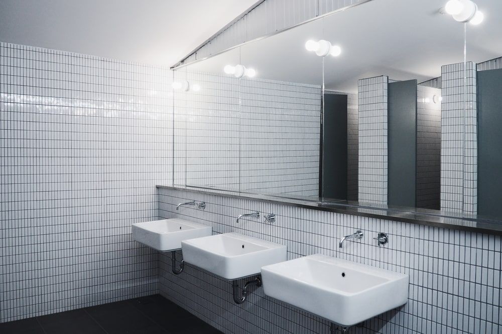 A Bathroom With Three Sinks And A Large Mirror — Frank Plumbing In Delacombe, VIC