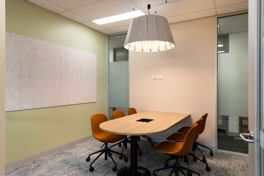 A Conference Room With A Table And Chairs And A Lamp Hanging From The Ceiling — Frank Plumbing In Delacombe, VIC