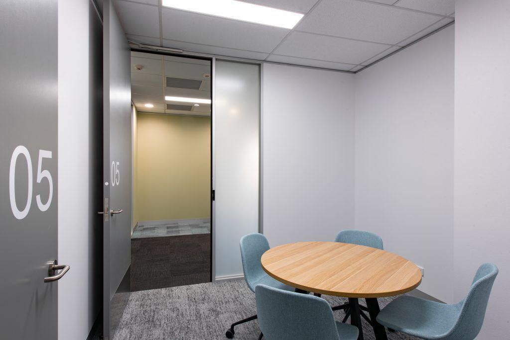 A Small Conference Room With A Round Table And Chairs — Frank Plumbing In Delacombe, VIC