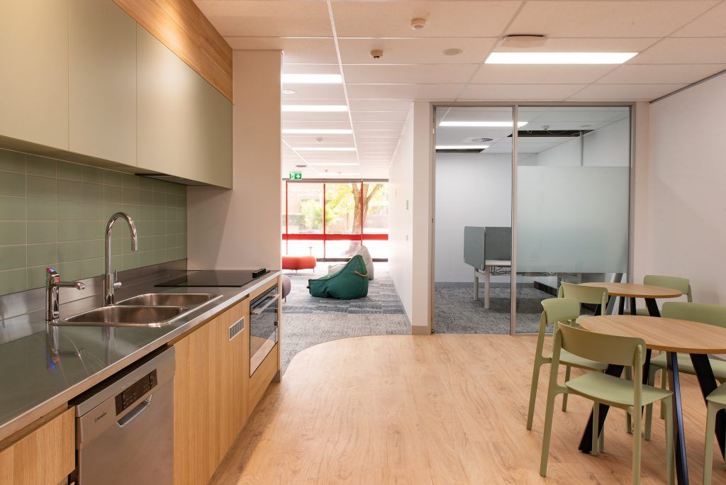 A Kitchen With A Sink , Dishwasher , Chairs And Tables — Frank Plumbing In Delacombe, VIC