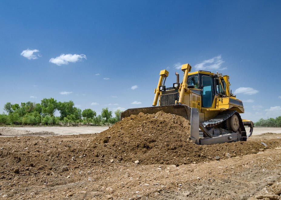 A Bulldozer is Moving Dirt on a Construction Site — Tallow Tree Services Pty Ltd in Lismore, NSW