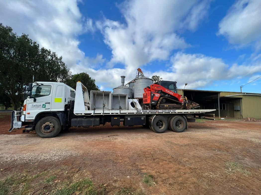 A Truck With a Crane on the Back of It is Parked in a Dirt Lot — Tallow Tree Services Pty Ltd in Casino, NSW