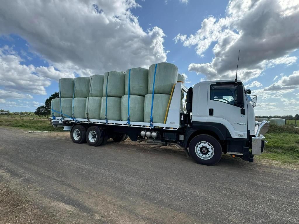 A Truck Loaded With Hay Bales is Parked on the Side of the Road — Tallow Tree Services Pty Ltd in Yamba, NSW