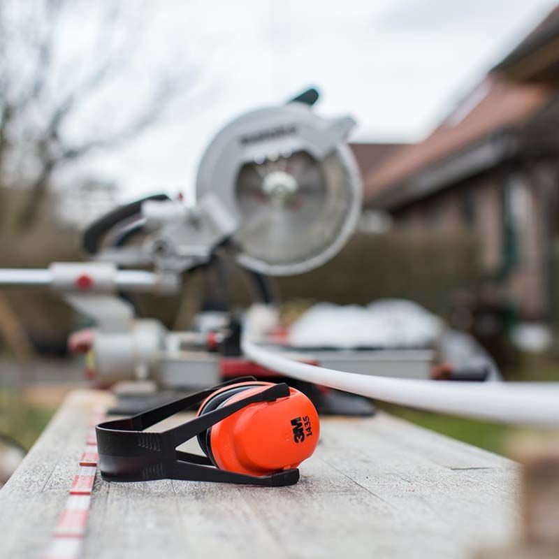 A pair of 3m ear protectors sitting on a wooden table