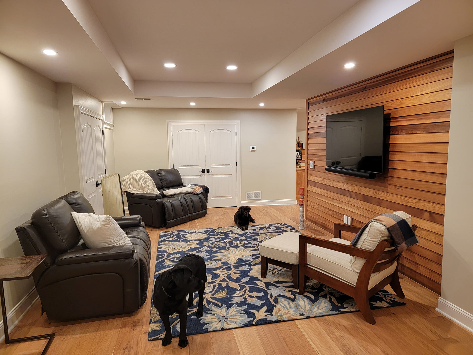 A living room with a couch , chairs , and a television.