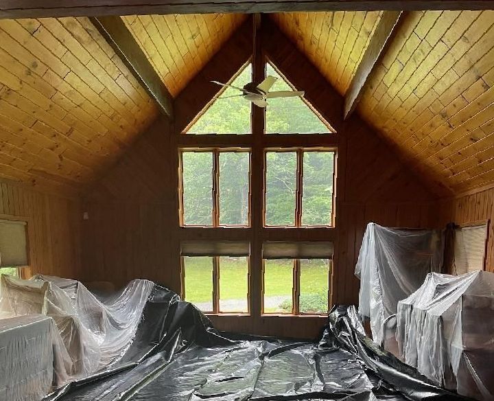 A room with a lot of windows and a ceiling fan