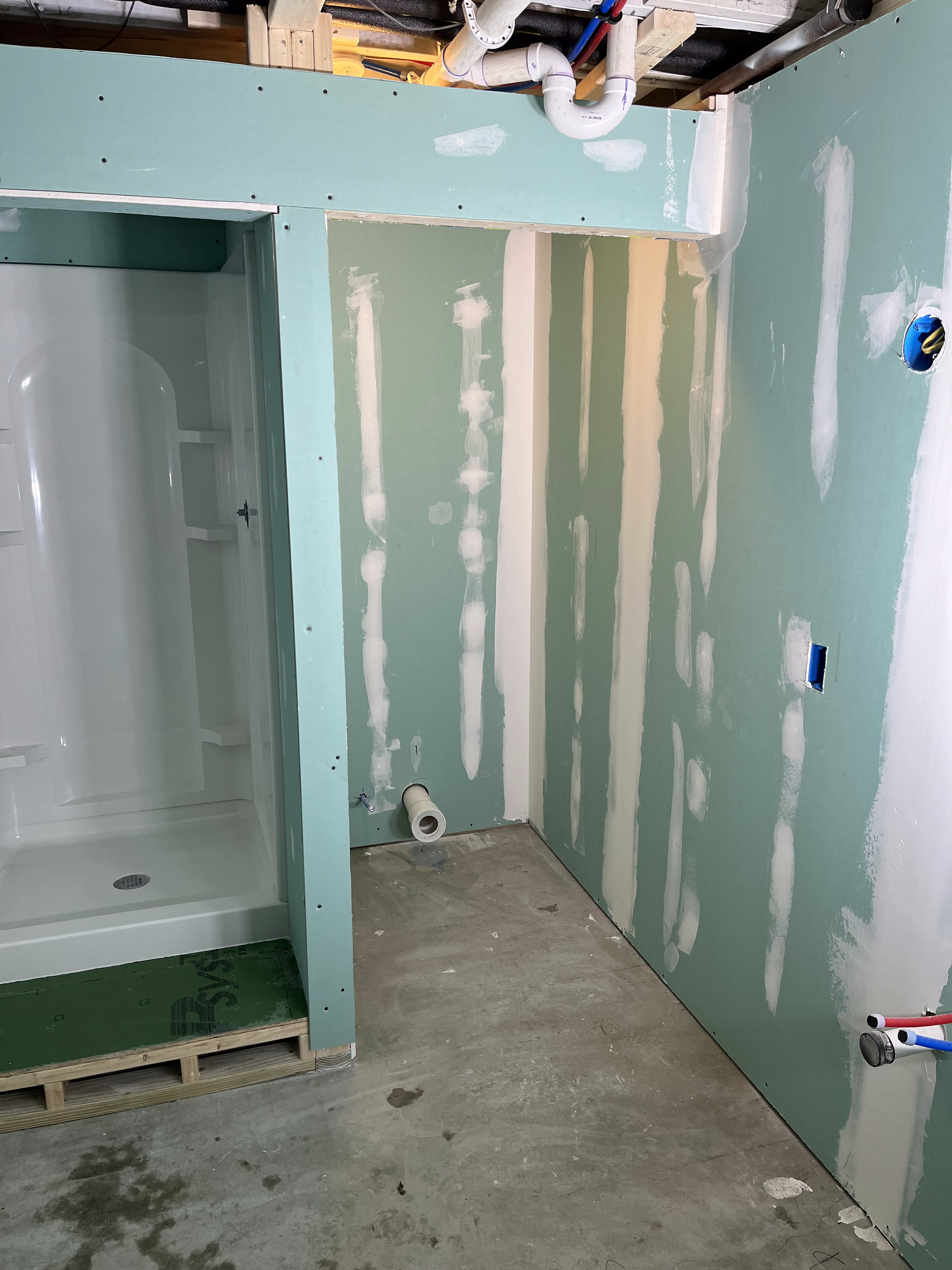 A bathroom under construction with a shower and a toilet.