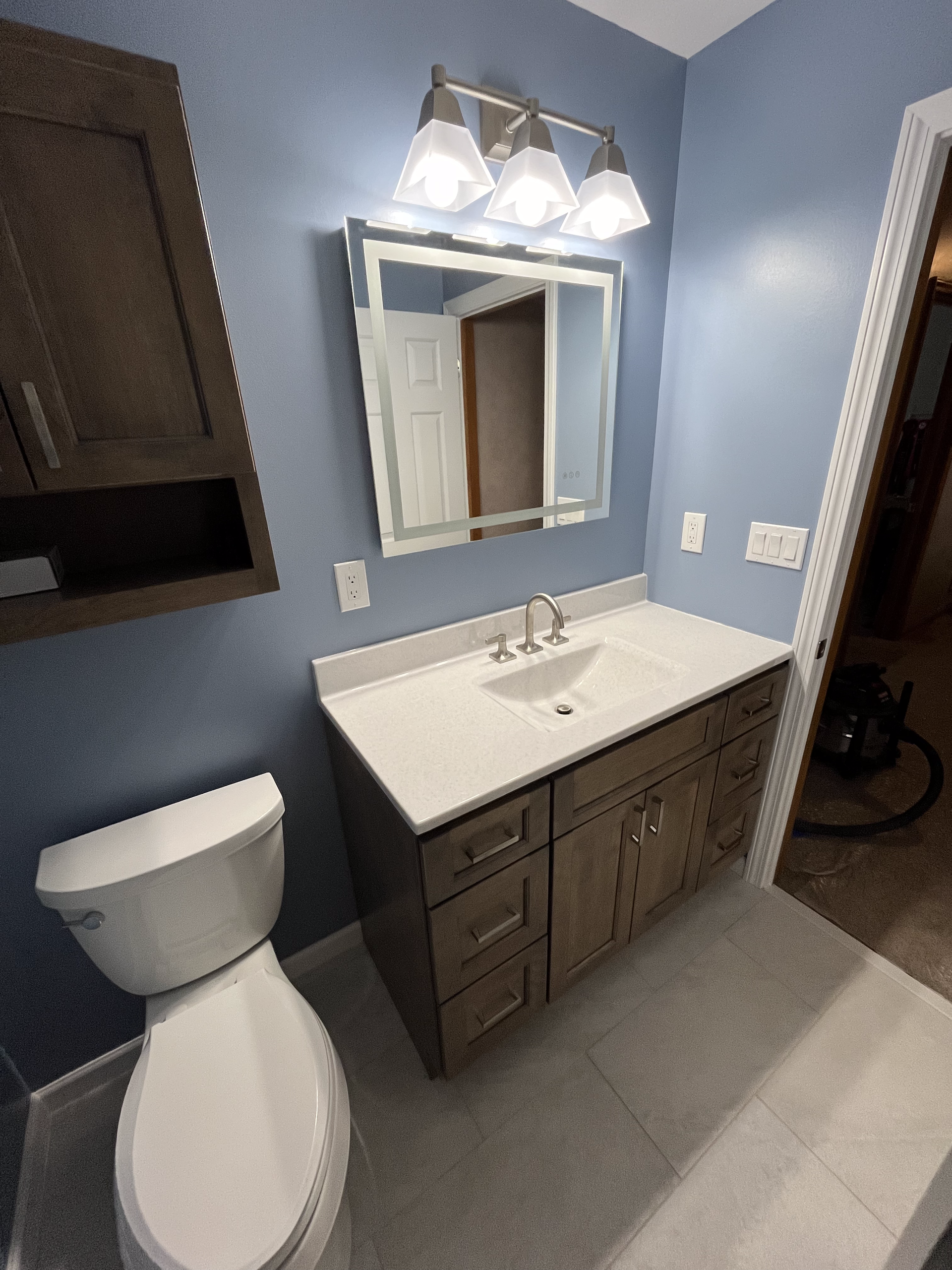 A bathroom with a toilet a sink and a mirror