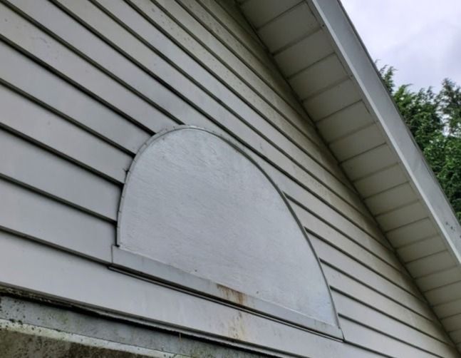 A white house with a round window on the side