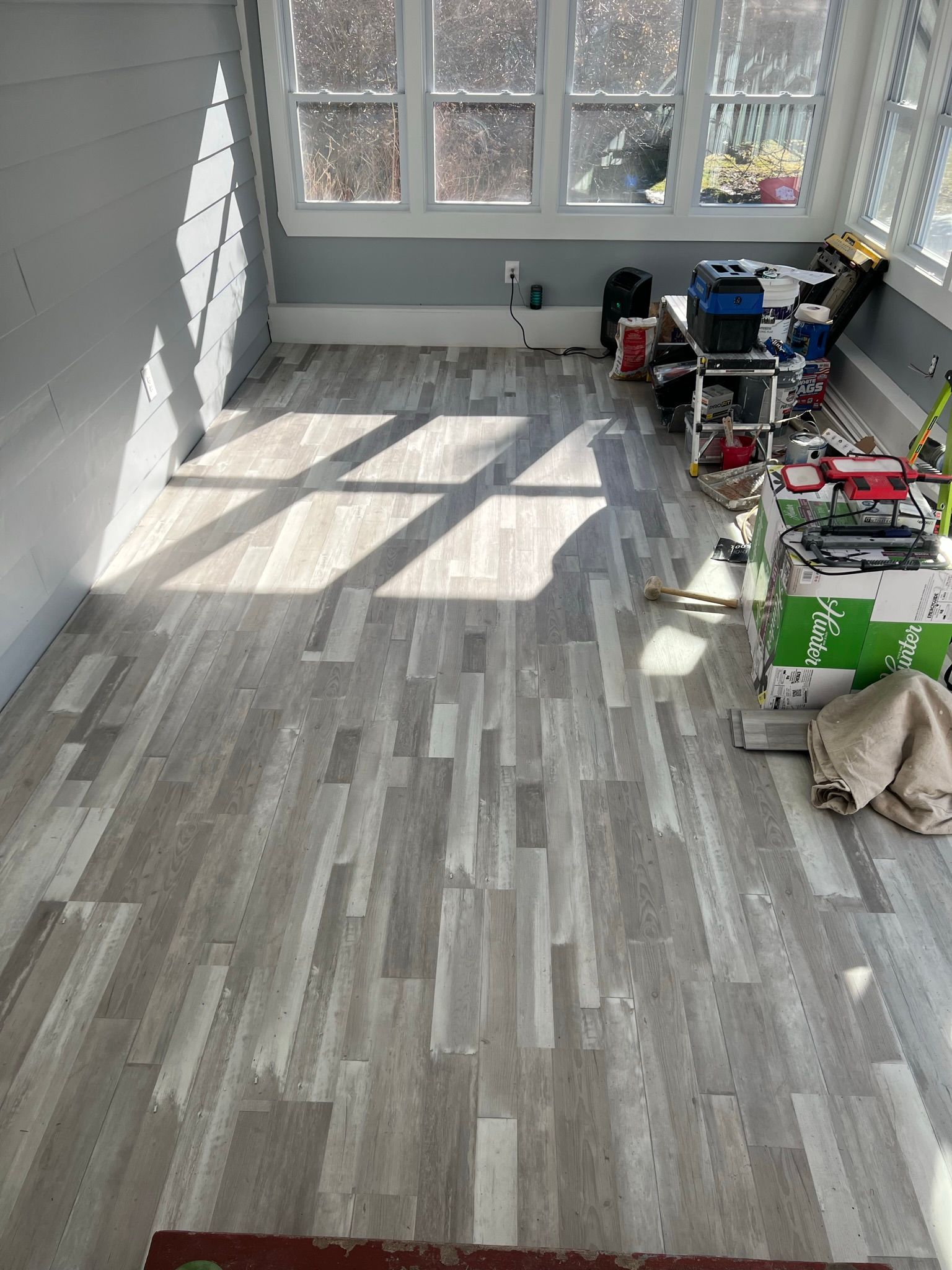A room with a wooden floor and a lot of windows.