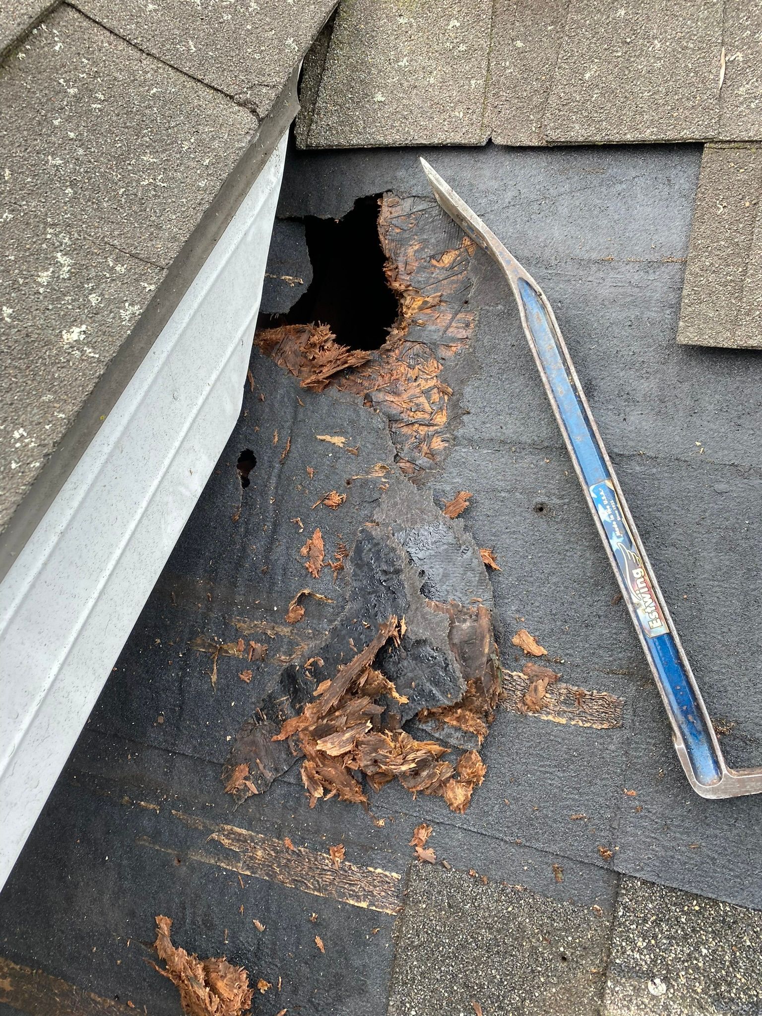 A roof with a hole in it and a tool on it.