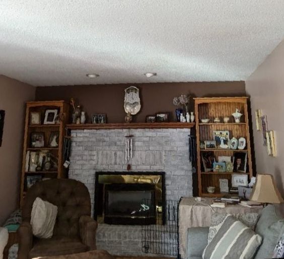 A living room with a fireplace and a clock on the wall