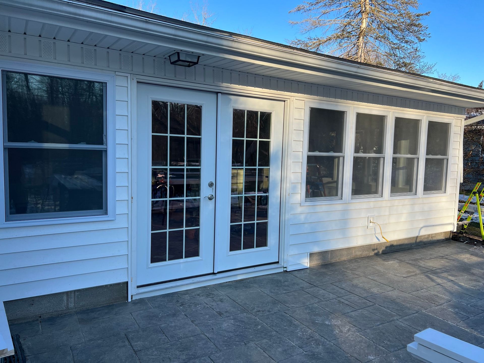 A white house with a screened in porch and french doors