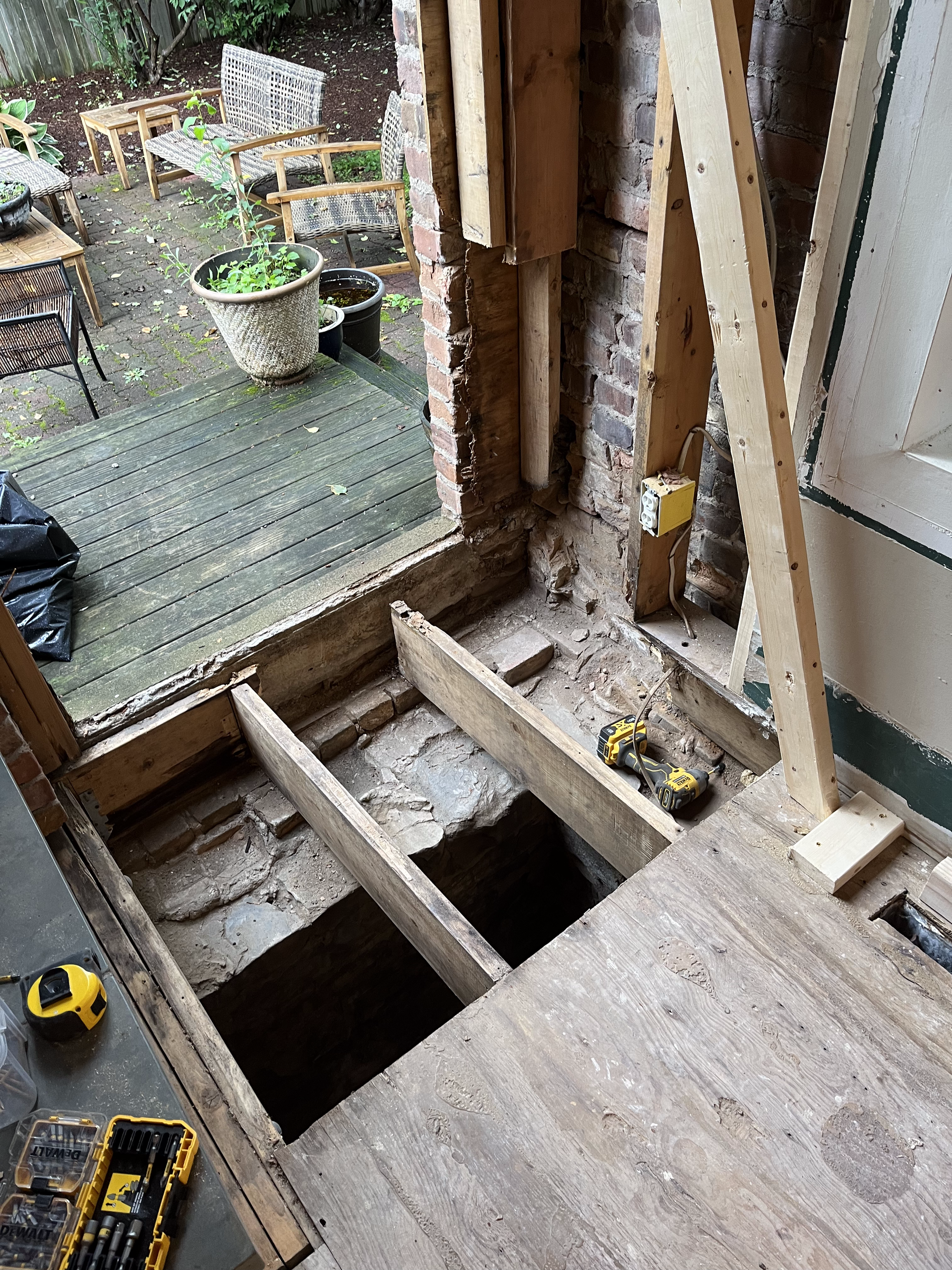 A wooden floor with a hole in it and a window in the background.