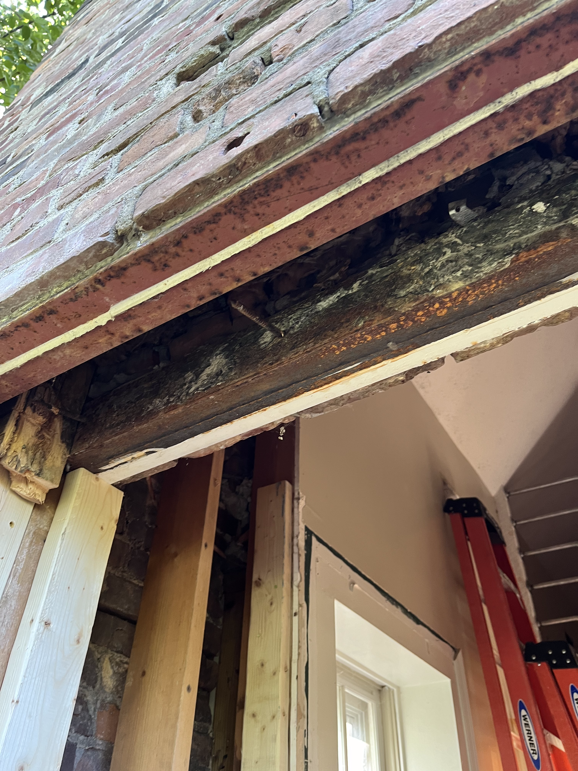 A ladder is sitting on the side of a building next to a window.