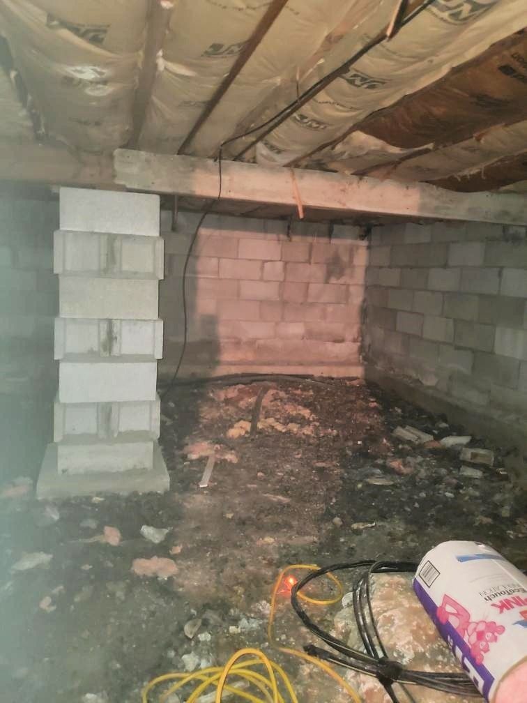 A basement with a lot of bricks and a yellow cord.