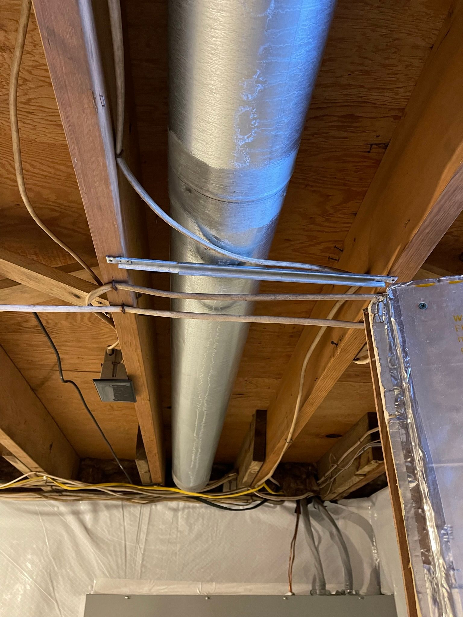 A metal pipe is hanging from the ceiling of a house.