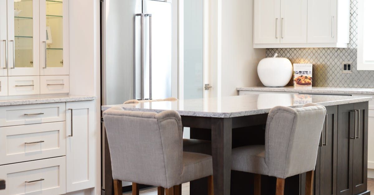 A kitchen with a table and chairs and a refrigerator.