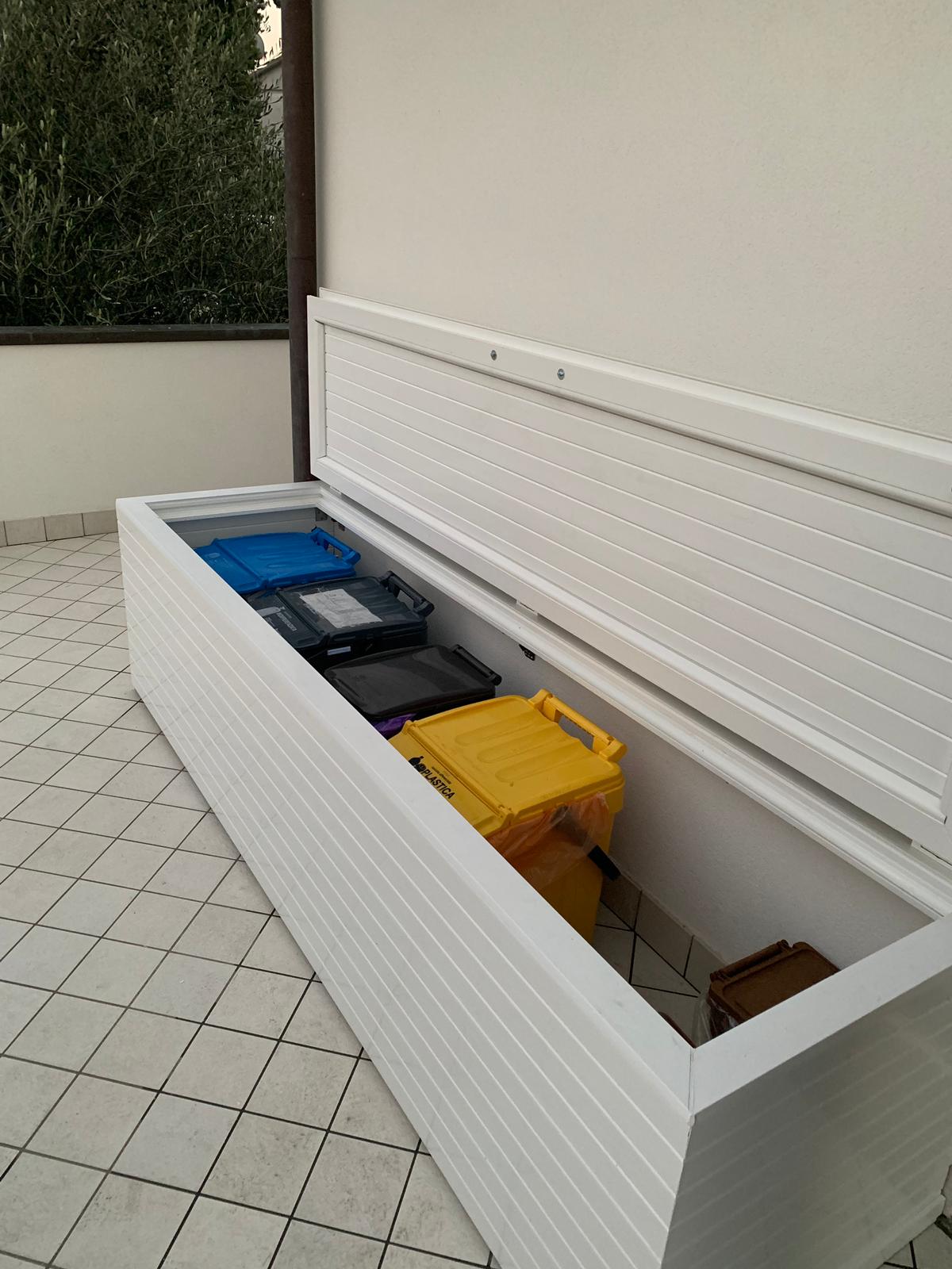 cassapanca aperta con bidoni rifiuti